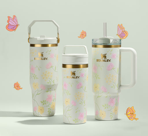 Three floral-patterned Stanley 1913 tumblers on a light background with decorative butterflies.